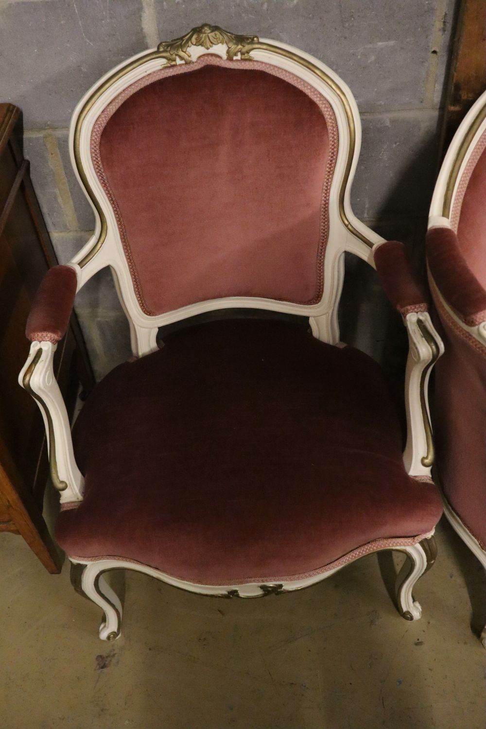 A Louis XV style cream and gilt painted carved wood framed canape and a pair of open armchairs, upholstered in pink dralon, settee widt